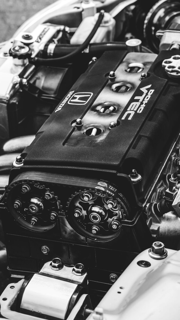 Detailed view of a Honda VTEC engine showcasing metal parts and gears in monochrome.